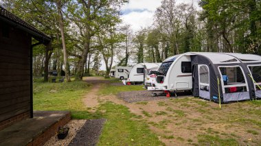 Norfolk kırsalında dört karavan ve bir karavanla dolu küçük bir kamp alanı..