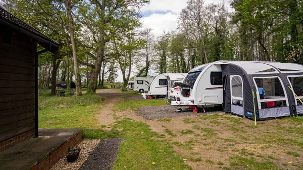 Norfolk kırsalında dört karavan ve bir karavanla dolu küçük bir kamp alanı..