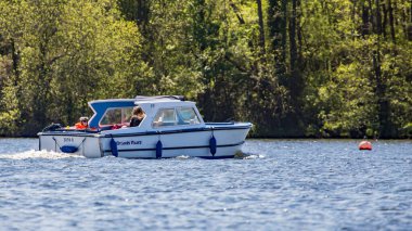 Wroxham, Norfolk, İngiltere - 12 Mayıs 2019. Broads Tours 'dan kiralanan turistlerin Norfolk Broad' un göbeğindeki Wroxham Broad 'da güneşli ve güneşli bir günde çekilmiş bir fotoğrafı.