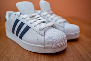  Norwich, Norfolk, İngiltere - 20 Ekim 2019. Ahşap zeminde mavi çizgili beyaz moda eğitmenlerinin seçici bir fotoğrafı.