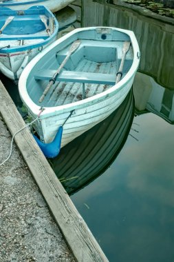 Norfolk Broads Ulusal Parkı 'ndaki Horning köyünde Bure Nehri' nin kıyısında demirli küçük kayıklar.
