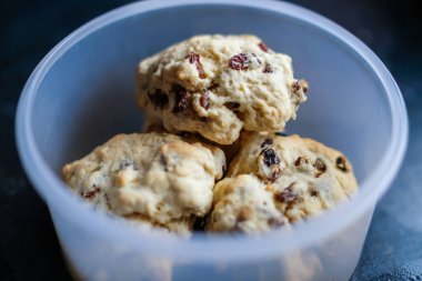 Ev yapımı ve ev yapımı meyveli çörekleri plastik bir kabın içinde, kapalı ve seçici bir odak ve kasıtlı bokeh