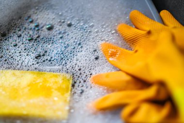 Marigold eldivenleri bir kase sabunlu suyla yıkadı. Bokeh ile yakınlaştır ve seçici odakla.