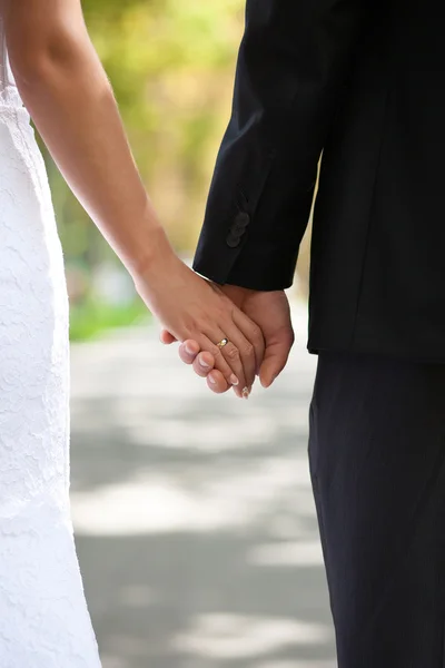 Hands of the bride and groom with a wedding ring on the street — Stock Photo, Image