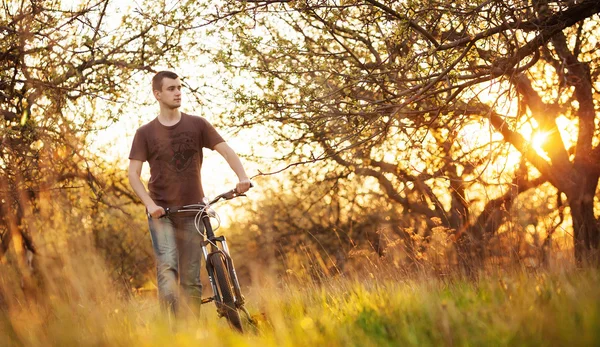 Uomo a piedi con una bicicletta — Foto Stock