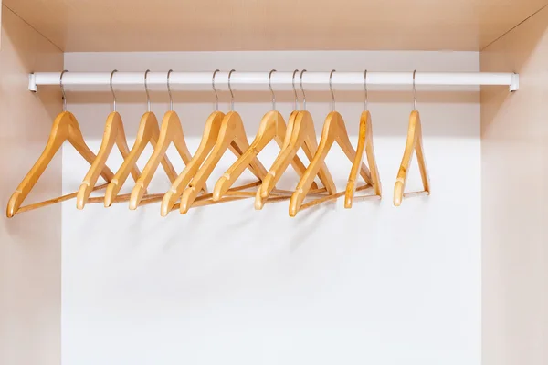 Wooden coat hangers on clothes rail — Stock Photo, Image