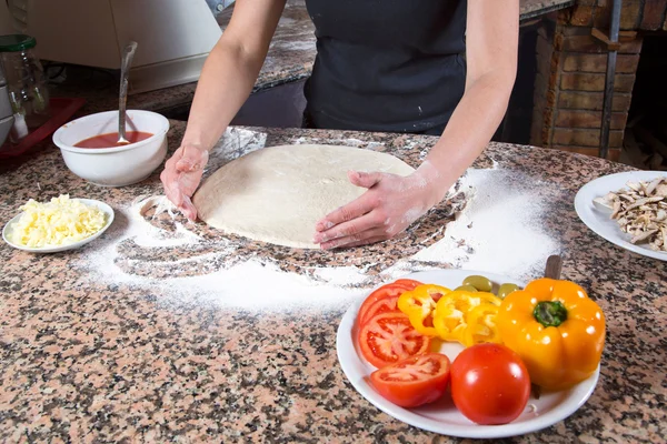 Vegetarische Pizzazubereitung - Bäcker knetet Teig umgeben von Zutaten auf Marmortisch — Stockfoto
