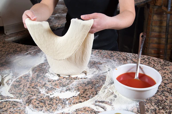 Bäcker knetet Teig für Pizza auf Marmortisch — Stockfoto