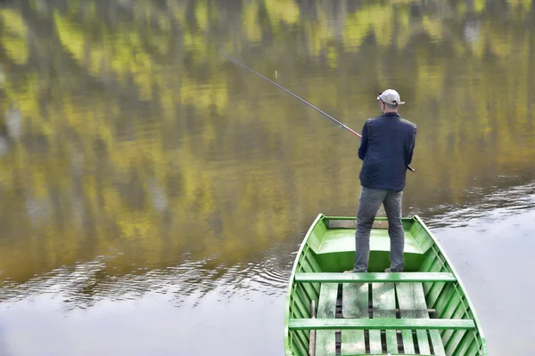 Scène de pêcheur avec son dos vers la caméra de pêche du bateau sur le lac calme — Photo