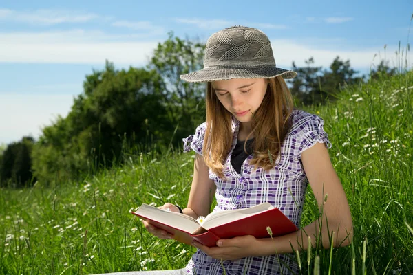 Tiro do meio-comprimento da menina loira do cabelo com chapéu que estuda ao ar livre na primavera ensolarada — Fotografia de Stock