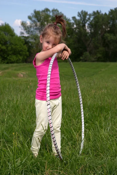 Mosolygós kislány Hula Hoop élvezi a szép tavaszi nap a parkban — Stock Fotó