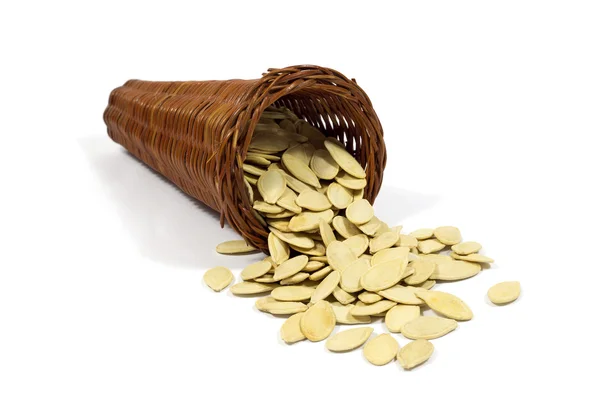 Macro tiro de sementes de abóbora assadas em cesta de vime isolado em branco — Fotografia de Stock