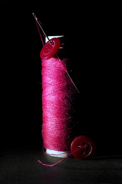 Spool of Red Thread with Needle and Red Buttons Isolated on Black — Stock Photo, Image