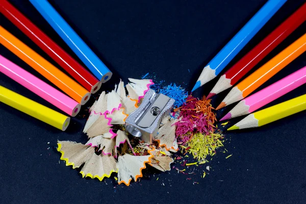 Sharpened Colorful Pencils Against Blunt Pencils with Metallic Pencil Sharpener and Colorful Pencil Shavings on Black — Stock Photo, Image