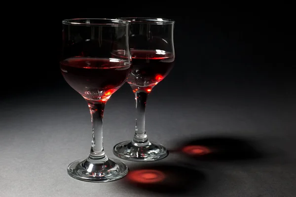 İki kadeh kırmızı şarap ve kara üzerinde ilginç kendi yansıması — Stok fotoğraf