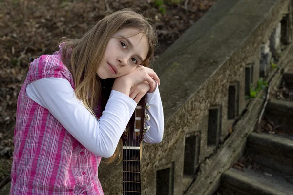 Pensive Girl s'appuyant sur la guitare et regardant la caméra contre de vieux escaliers — Photo