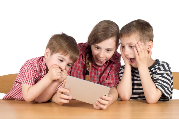 Frères et sœur étonnés avec tablette numérique isolé sur blanc — Photo
