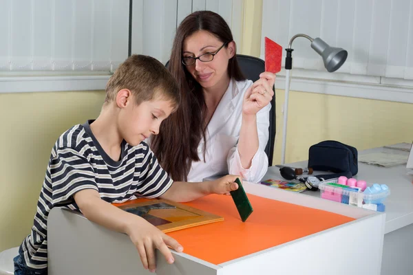 Doctor Examining Little Boy's Logical Thinking With Colored Geometric Shapes in Consulting Room — Stock fotografie