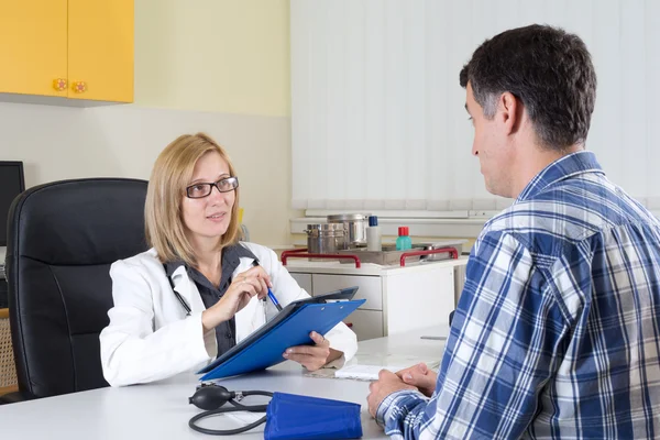 Female Doctor and Middle Aged Patient Talking in Consulting Room — Stock Photo, Image