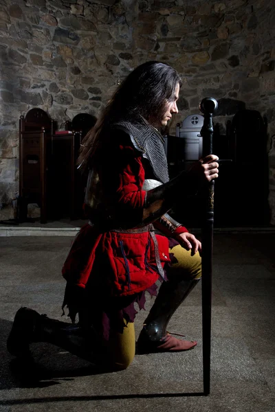 Вид сбоку на рыцаря с мечом, орущего в старой церкви — стоковое фото