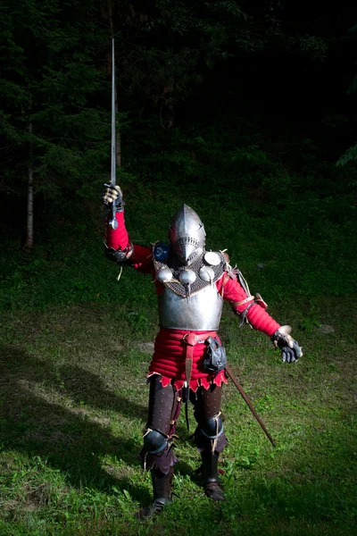 中世纪的骑士，用剑在举起的手，在夜里在森林里 — 图库照片