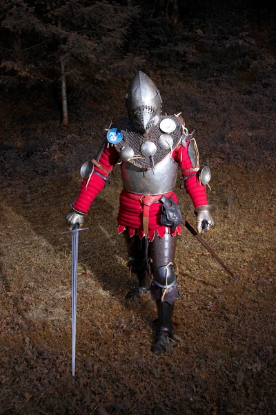 Guerreiro medieval de terno de cavaleiro em pé na floresta escura pronto para a batalha — Fotografia de Stock