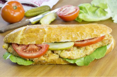 Ahşap üzerinde taze sebze ile lezzetli tavuk sandviç yemeye hazır masa