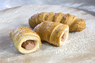 Sosis Rolls susam ile unlu ahşap tahta üzerinde ikiye böldüm