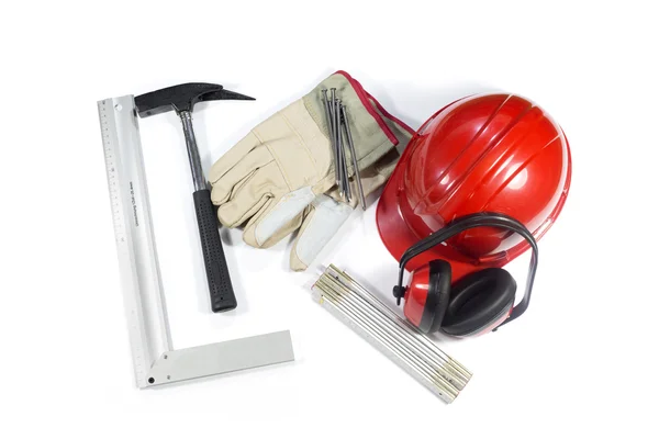 Σύνολο των οικοδομικών εργαλείων - προστατευτικό ωτοασπίδες, σφυρί, καρφιά, γάντια, προστατευτικό κράνος και διπλώνοντας χάρακα απομονωθεί σε λευκό — Φωτογραφία Αρχείου