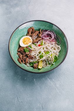 Beton arka planda kasede sığır etli Pho Bo Vietnam Çorbası