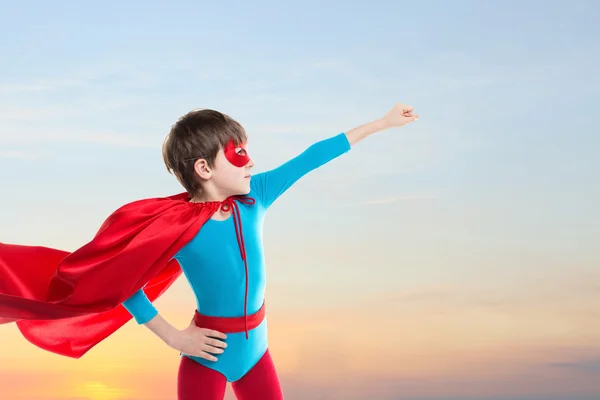 Miúdo super-herói voando no céu por do sol . — Fotografia de Stock