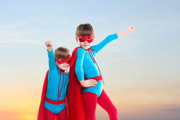 Super-herói meninos no por do sol céu fundo . — Fotografia de Stock