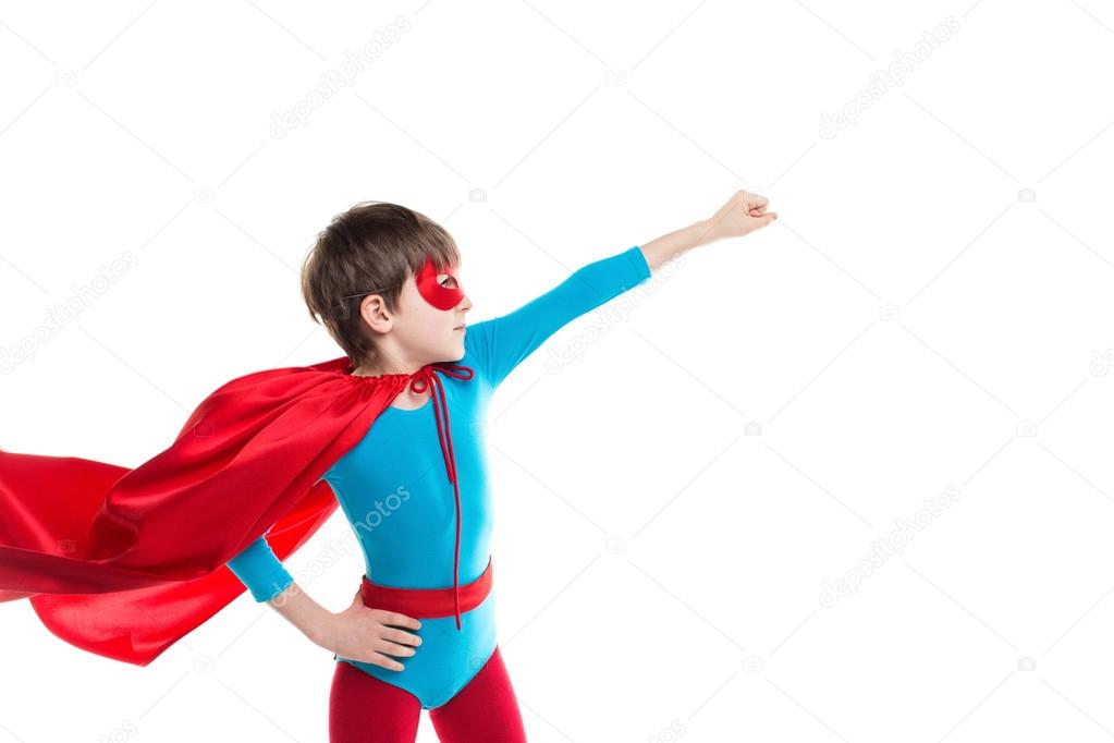 Boy dressed as superhero poses in studio.