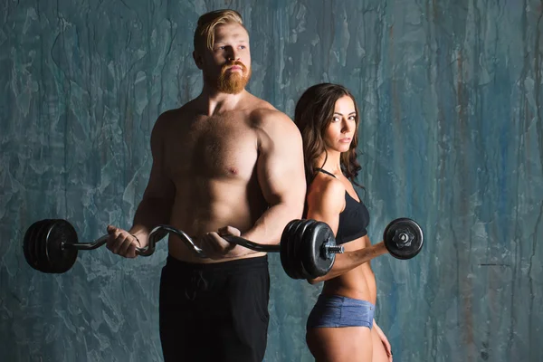 Fuerte pareja joven haciendo ejercicio con pesas . —  Fotos de Stock