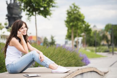 İletişim. Kadın parkta telefonda söz.