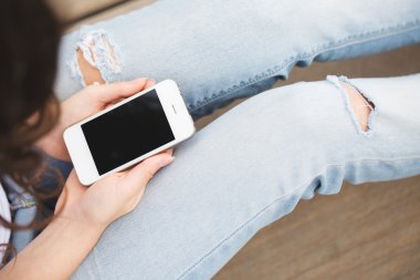 Üstten Görünüm telefon elinde tutan bir kadın görüntüsünü kırpılmış.