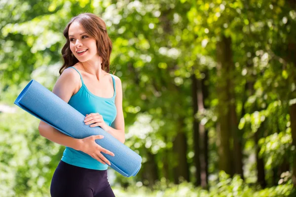 Dışarıda yoga minderli güzel bir kadın.. 