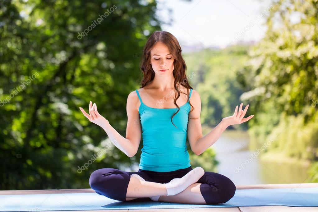 Yoga. Girl doing exercises in the park. Stock Photo by