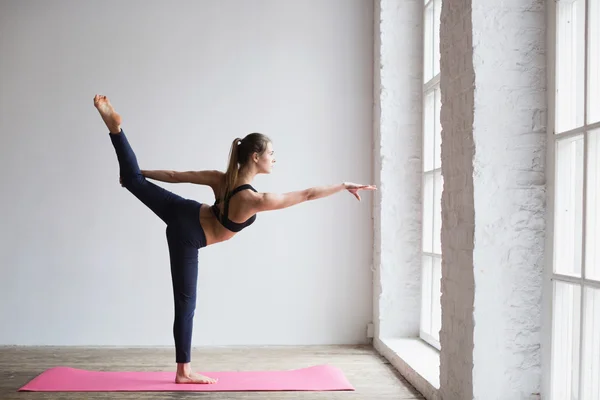 Jonge vrouw doet stretching oefening op yoga mat. — Stockfoto