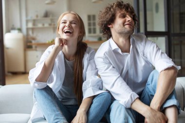 Mutlu Milenyum Kafkasyalı Çiftler evdeki koltukta oturup video konuşmaları, webcam 'de konuşmalar.