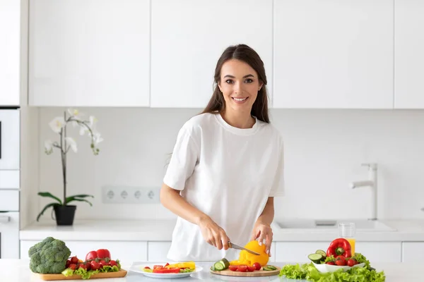 明るいキッチンで新鮮な野菜のサラダを準備若い美しい女性 健康的な食事 — ストック写真