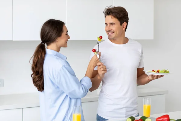 Happy Couple Feeding Each Other Smiling While Cooking Kitchen Home — Stock Photo, Image