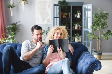 Not defterli genç ve güzel bir çift kanepede oturarak ev içinde planlar yapıyor. Ev hayatı..