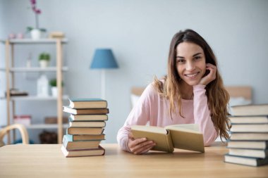 Bir grup kitapla masada oturan mutlu kız öğrenci, sınavlara hazırlanıyor..