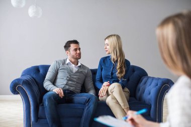 Başarılı psikolog eşi ve kocasını ziyaret eden mutlu çift kanepede birlikte oturuyor. Aile danışmanlığı