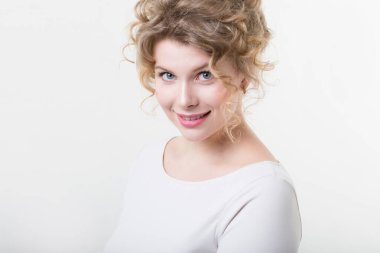 Beautiful natural curly woman with a sincere smile on a white background. Studio shot. 