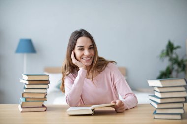 Bir grup kitapla masada oturan mutlu kız öğrenci, sınavlara hazırlanıyor..