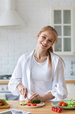 Genç bayan mutfakta sebze hazırlıyor, sağlıklı yiyecekler..