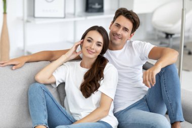 Evdeki kanepede dinlenen genç bir çift. İçerideki mutlu güzel insanlar.