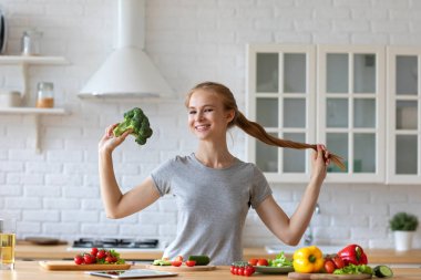 Mutfakta güzel bir vejetaryen kadın brokoliyle eğleniyor. Sağlıklı kalın.